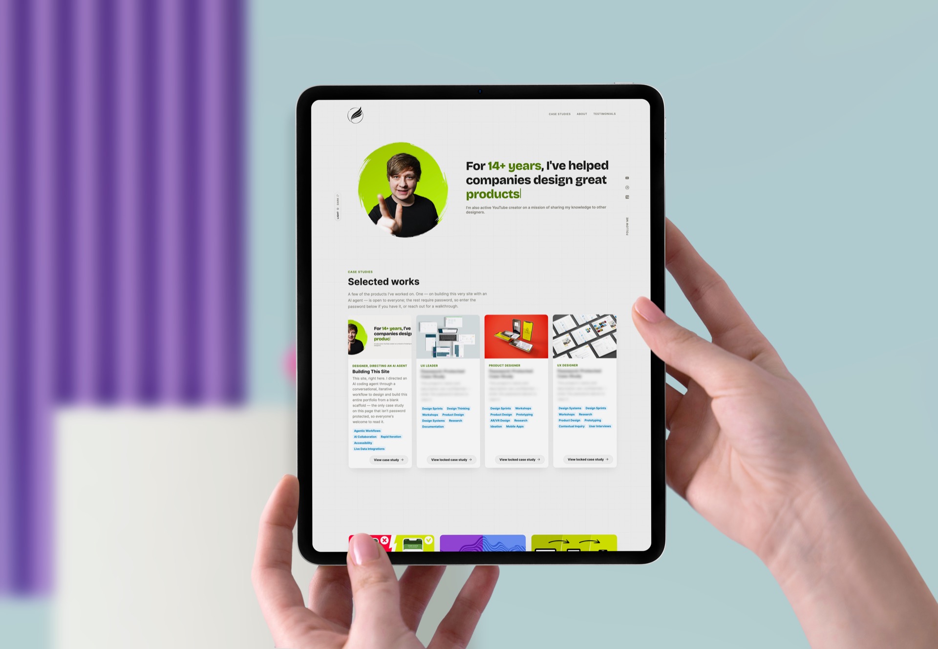 This portfolio's homepage hero and Selected Works section shown on an iPad, held in both hands