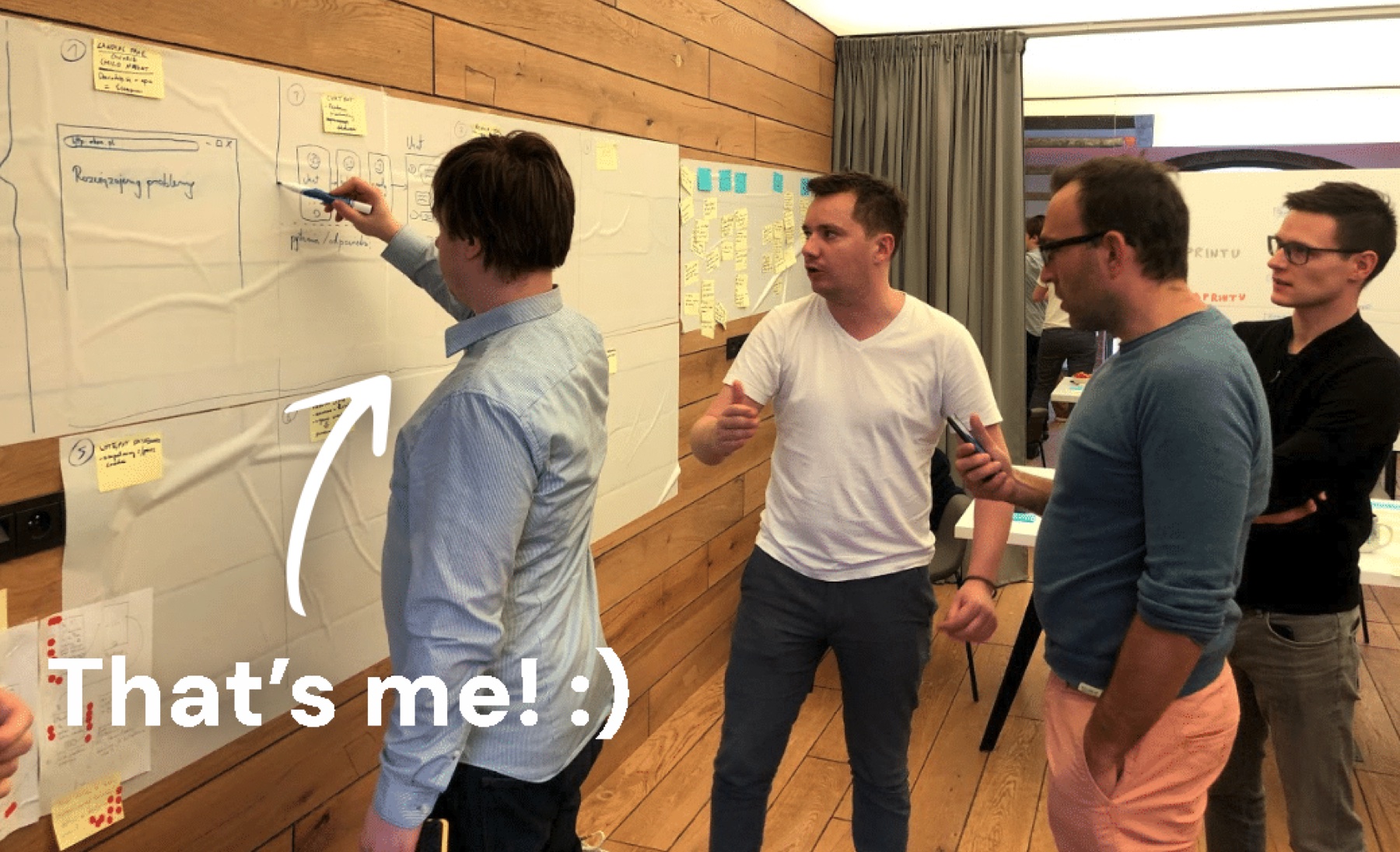 Team members gathered around a whiteboard covered in Design Sprint sticky notes during the Rhea workshop